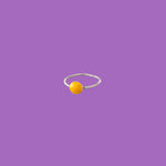 This brass ring features a medium-sized light orange enameled circular accent.