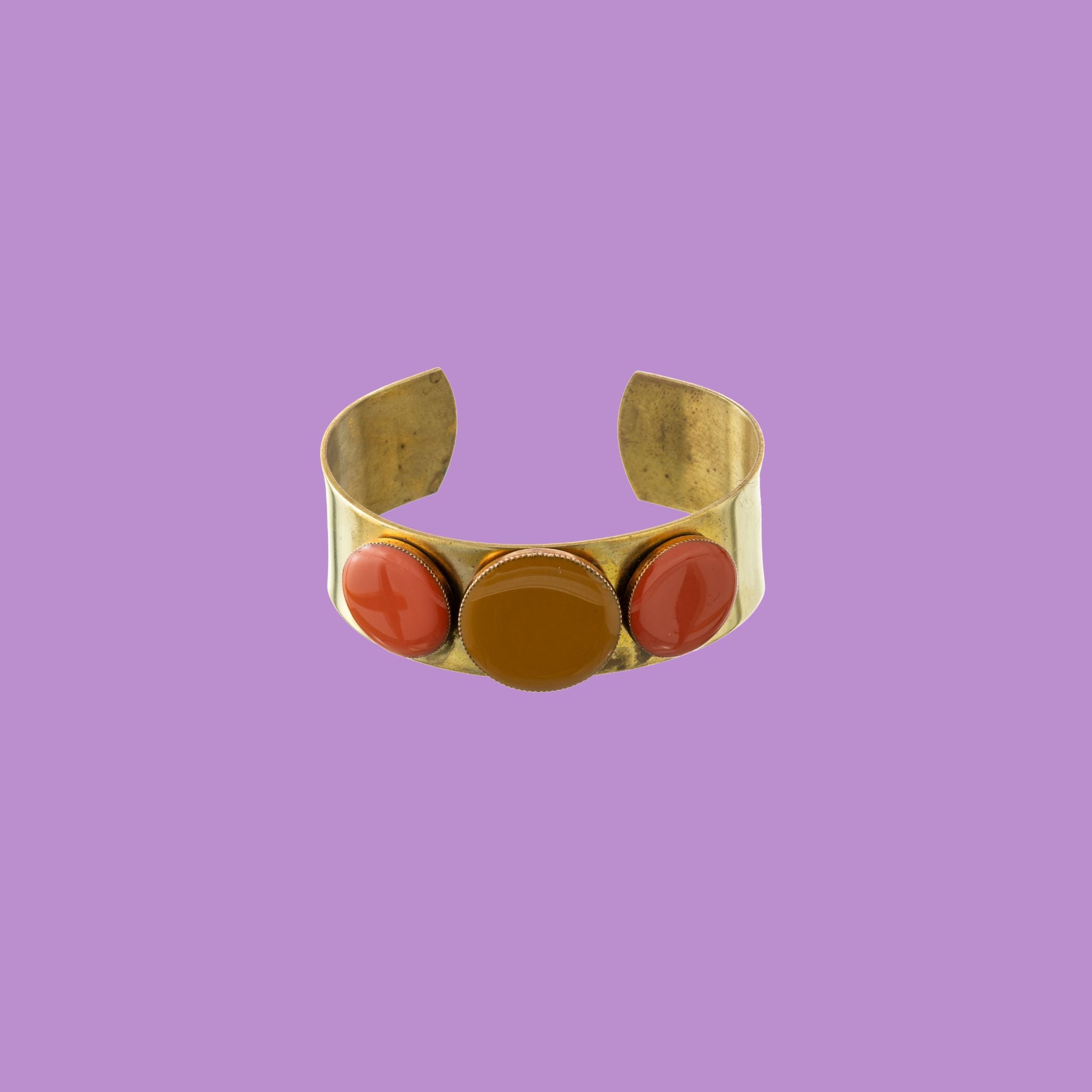 Bracciale Jessica Rabbit in ottone di Celeste Generoso, con tre decorazioni rotonde colorate e una fascia spessa.