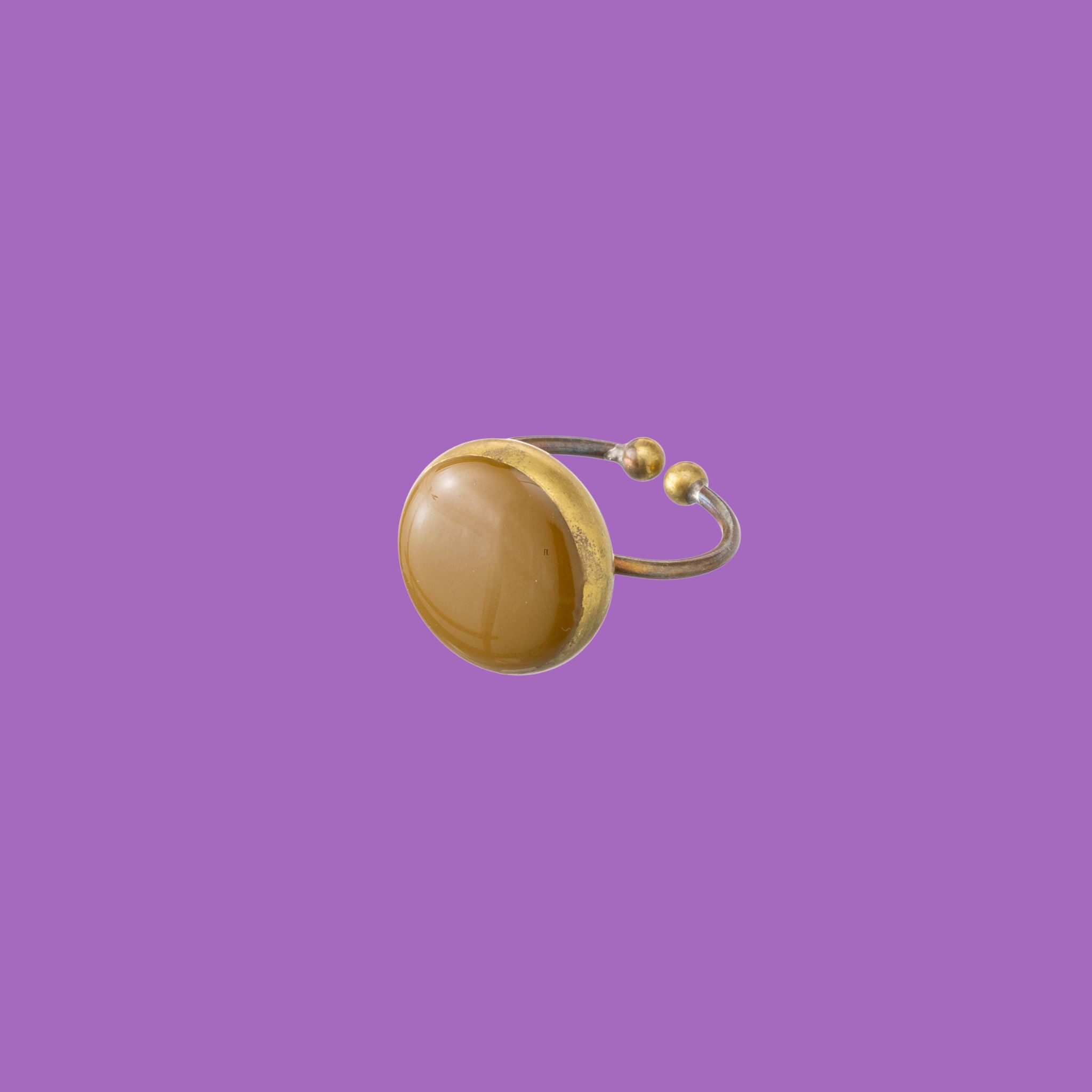 Realizzati in ottone di alta qualità, questi anelli presentano una raffinata applicazione rotonda smaltata in marrone.