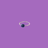 Questo anello in ottone presenta un elemento circolare smaltato di medie dimensioni color blu scuro.