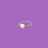 Questo anello in ottone presenta un elemento circolare smaltato giallo scuro di medie dimensioni.