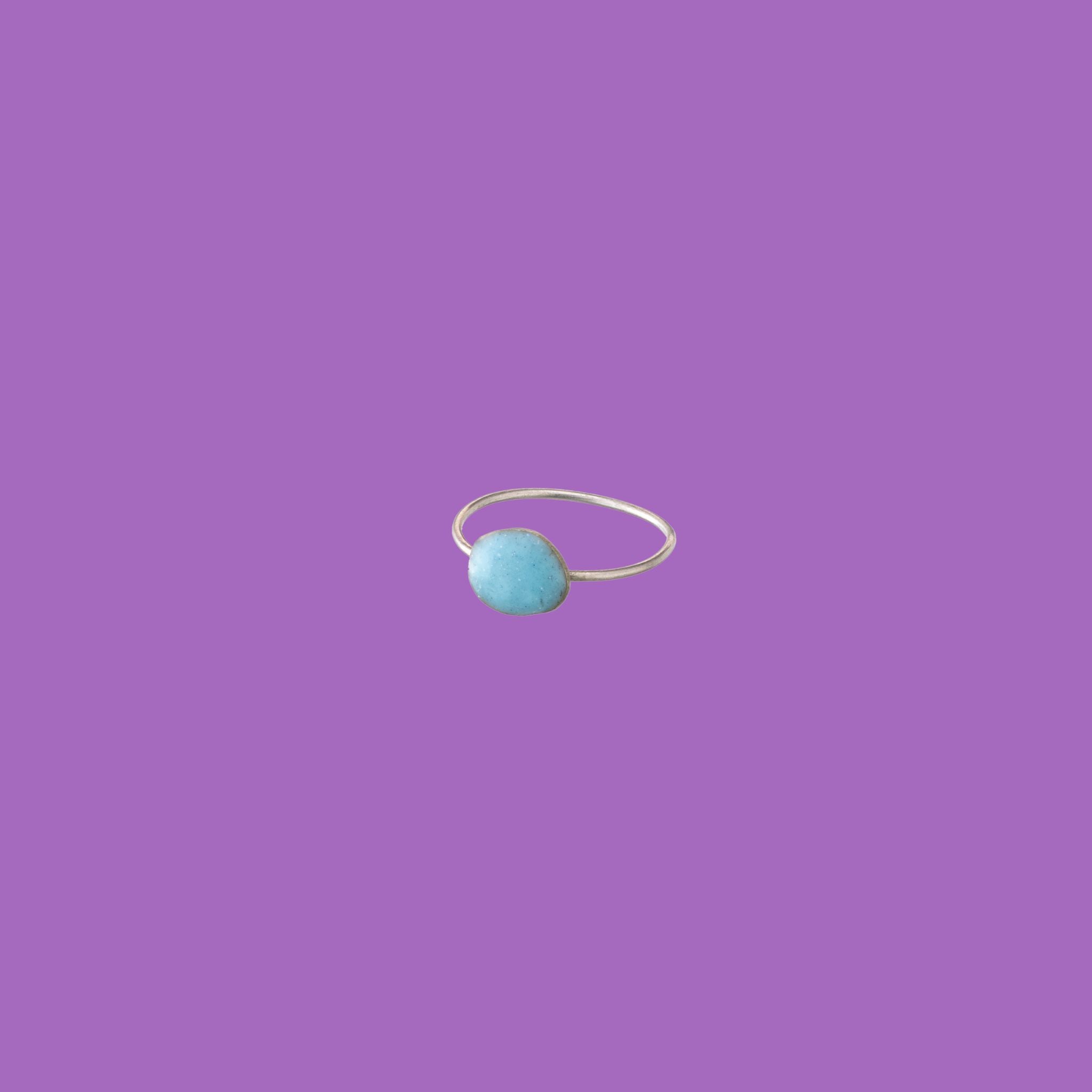 Questo anello in ottone presenta un accento circolare smaltato azzurro di medie dimensioni.