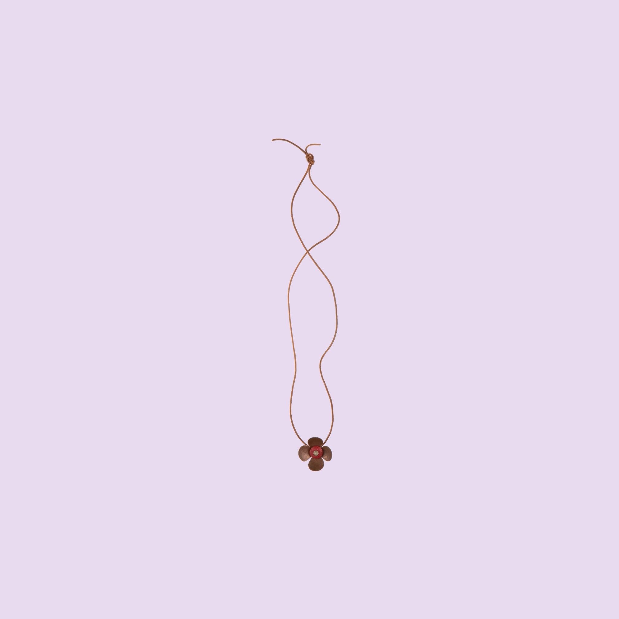 Realizzata a mano da Fabian Crosta, la collana in ottone Flower presenta un ciondolo a forma di fiore su un cordoncino.