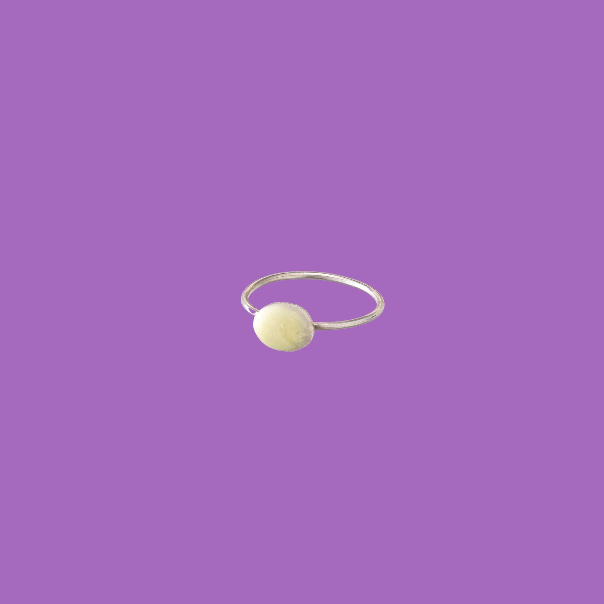 Questo anello in ottone presenta un accento circolare smaltato giallo di medie dimensioni.